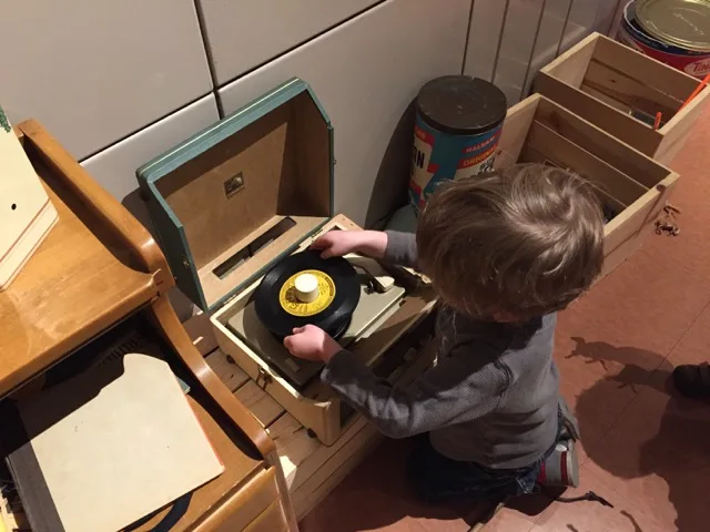 boy putting a record on a record player inside the Lustron house at Ohio History Center