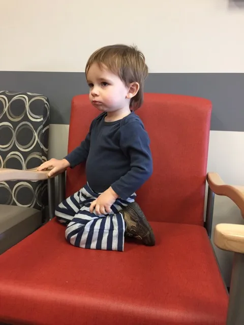 Sitting at the doctor's office looking sad.