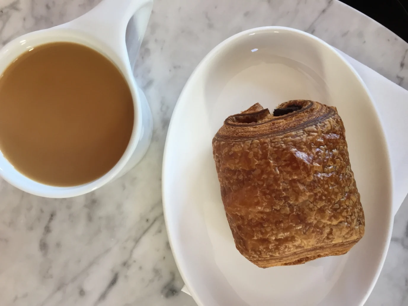 a cup of coffee and Pain Au Chocolat from Pistacia Vera, a french bakery in Columbus Ohio 