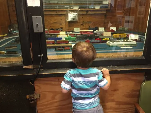 boy looking at a model train at the museum