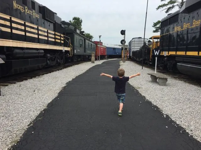 boy walking through the outdoor portion of the train museum