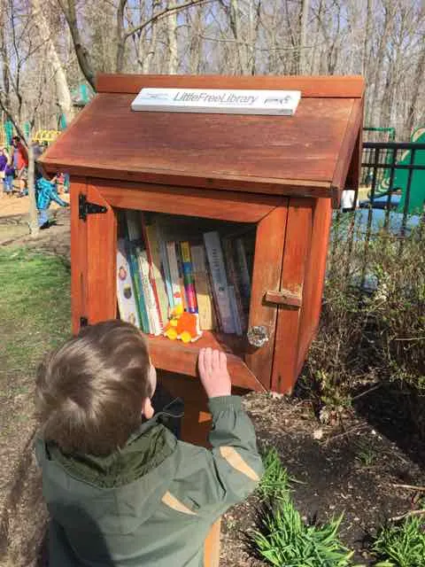 kid getting a book from a little free library in columbus, ohio