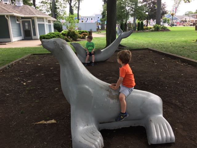 Two boys sitting on animal statues at DeRivera Park.