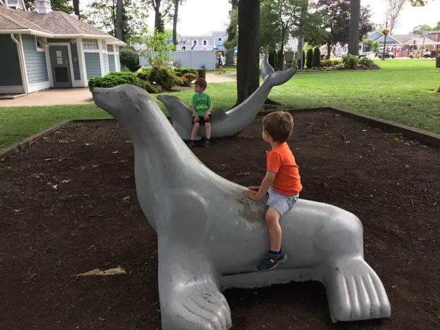 Two boys sitting on animal statues at DeRivera Park.