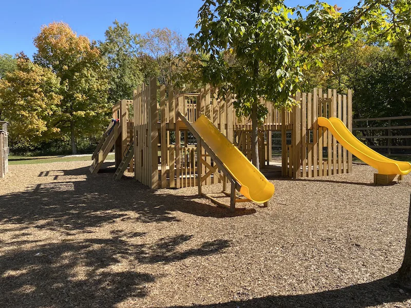 wooden playground area with yellow slides
