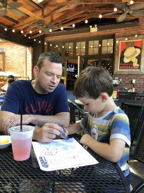 boy and father coloring on the kids menu at The Goat