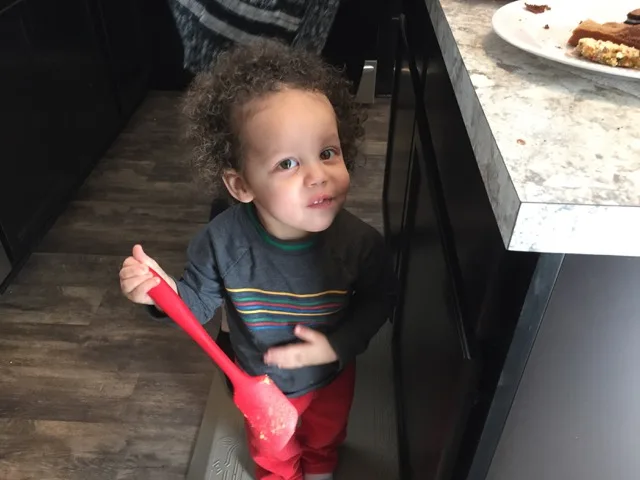 Little boy licking spatula