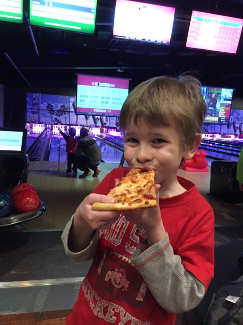 kid eating pizza at Ten Pin Alley