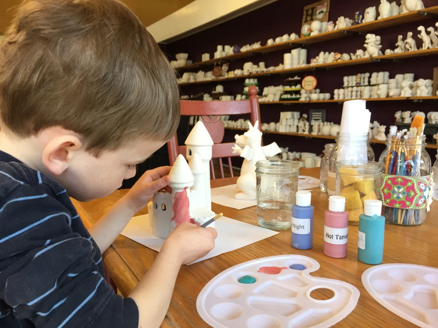 Boy painting pottery at The Studio in Hamilton, OH