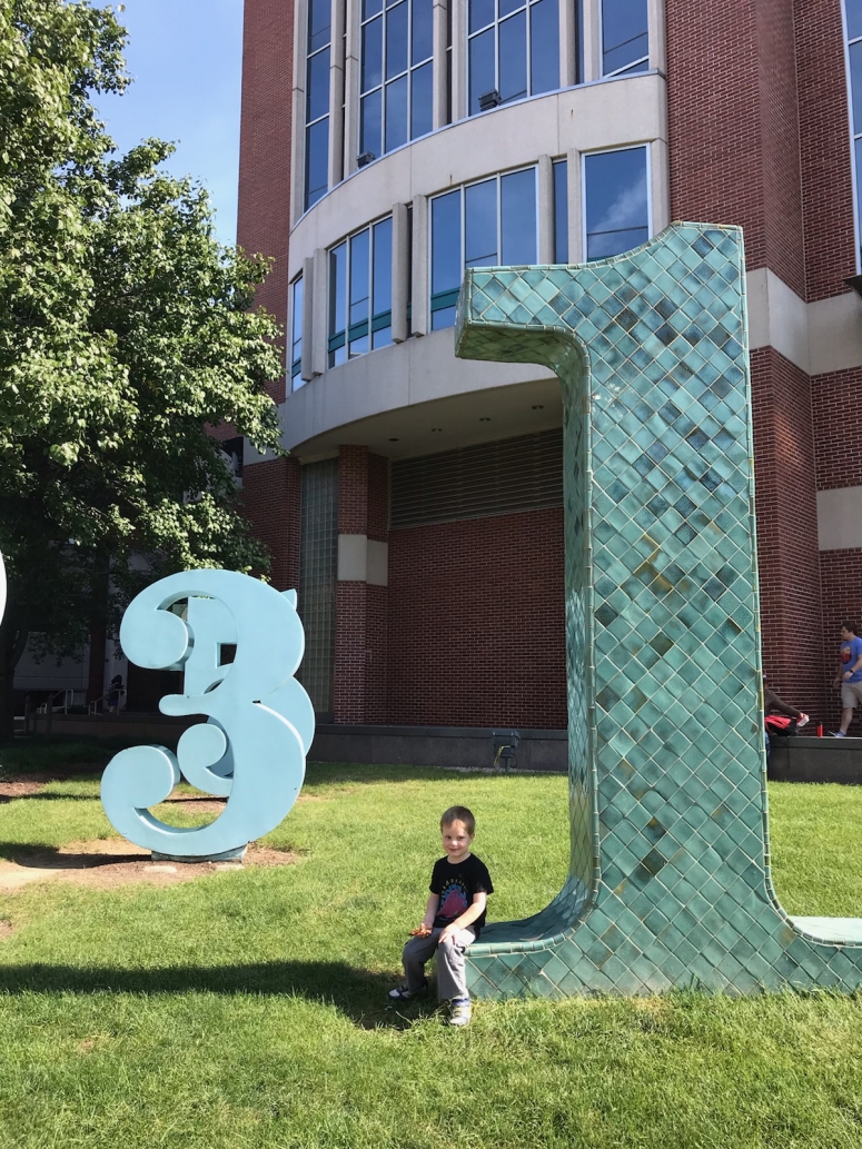 kid sitting at the Garden of Constants at Ohio State University Campus