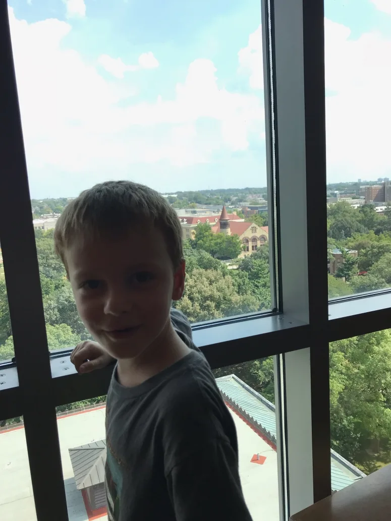 kid looking out the window at Thompson Library, Ohio State University Campus