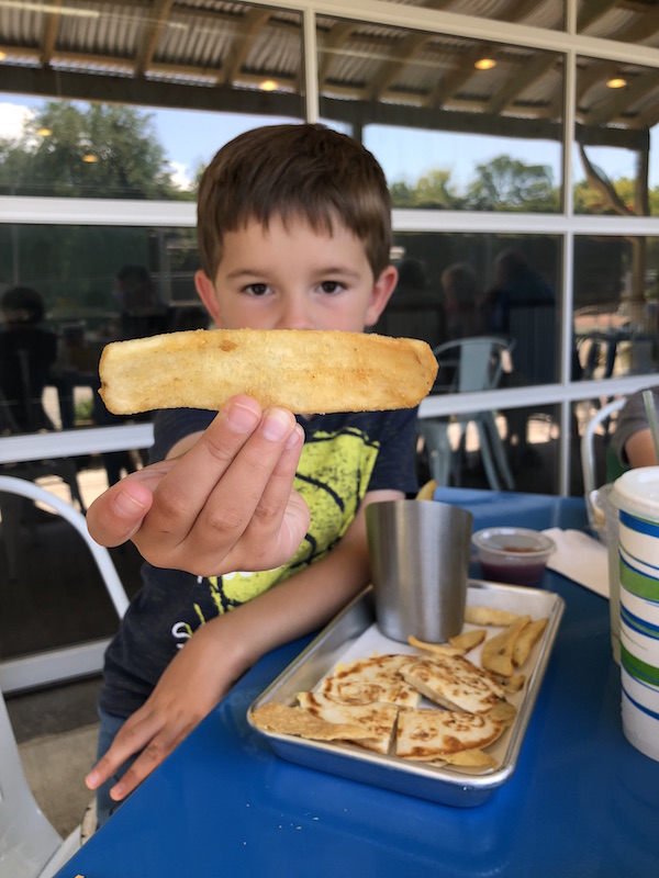 boy holding up french fry at Lago Coastal Cafe in Lakeside, Ohio