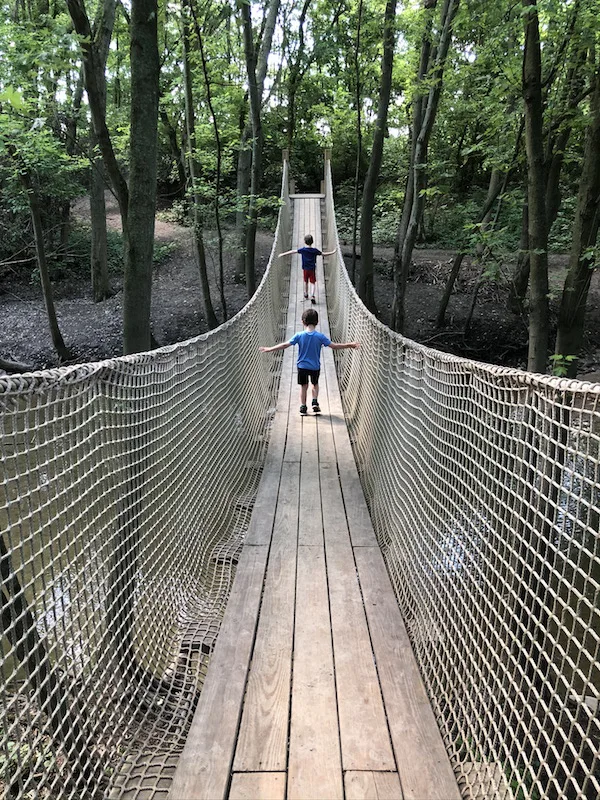 two boys walking the rope bridge in Scioto Grove Metro Park