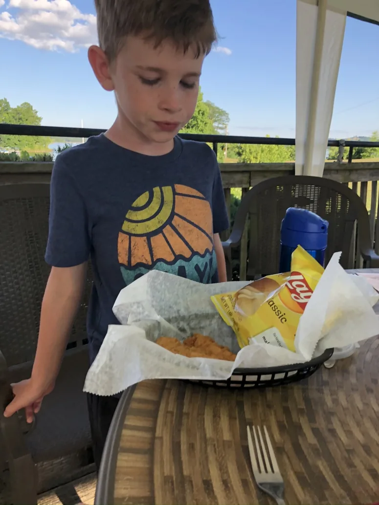 boy eating food at the Dockside Restaurant at Seneca Lake Marina