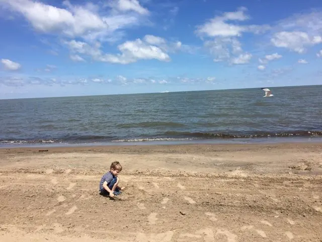 boy digging in sand on Port Clinton City Beach, Ohio