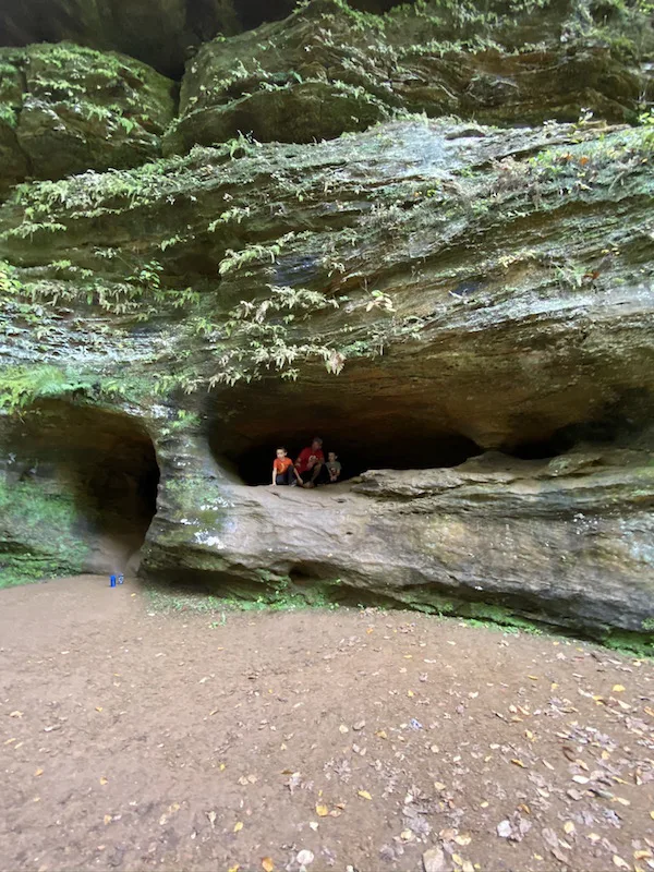 man and two boys inside a cave at Hocking Hills in Ohio