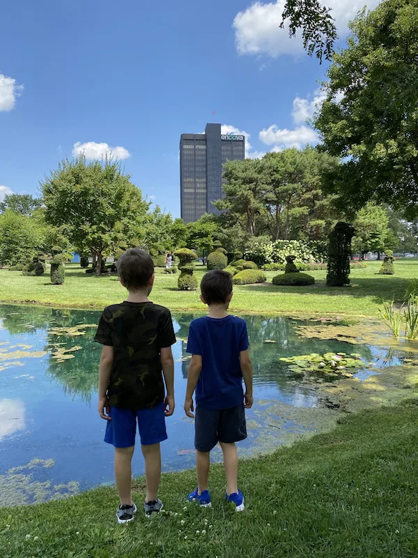 two boys standing by the water in Topiary Park.