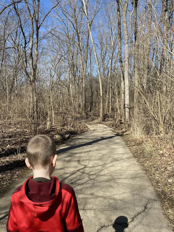 a boy walking on the multi-purpose trail in woodside green park in gahanna.