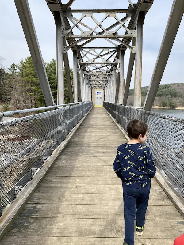 boy walking on the bridge at Pleasant Hill Dam in Mohican State Park.