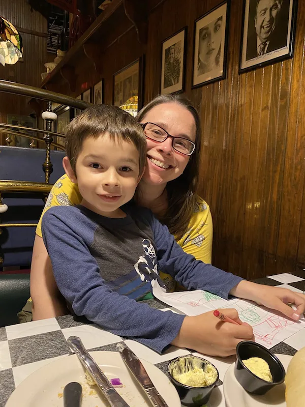 boy sitting on mom's lap in a restaurant booth.