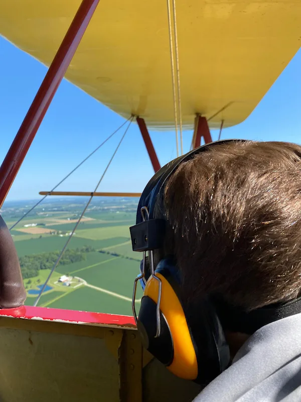 A boy looking at the view from a bi-plane flight at Goodfolk & O'Tymes Biplane Rides.