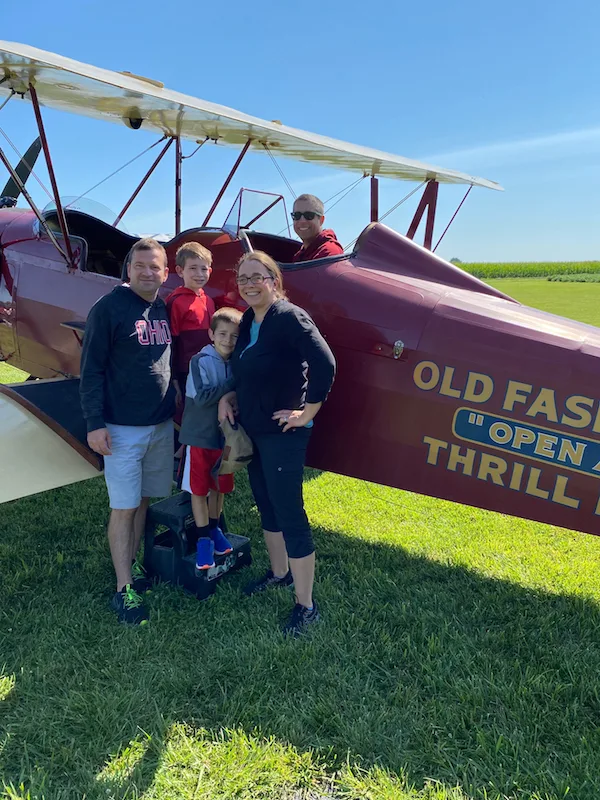 family in front of a bi-plane in on a road trip from Columbus to Greene County, Ohio!