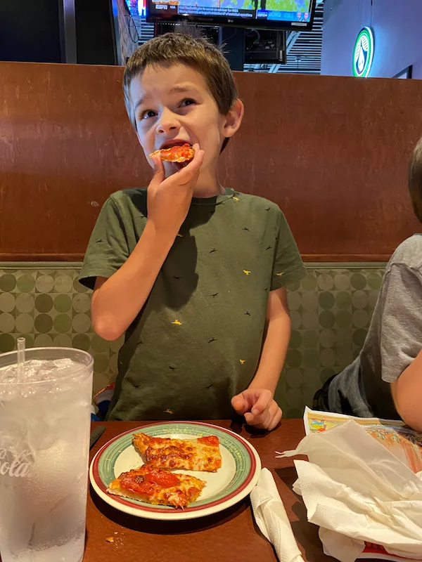 Boy eating pizza at Milano's in Greene County, Ohio.
