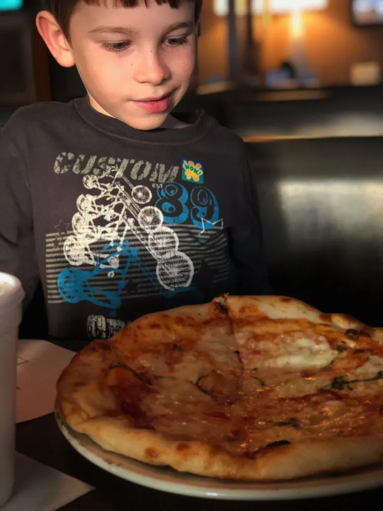boy eating a pizza at Little Palace Restaurant in downtown Columbus, Ohio.