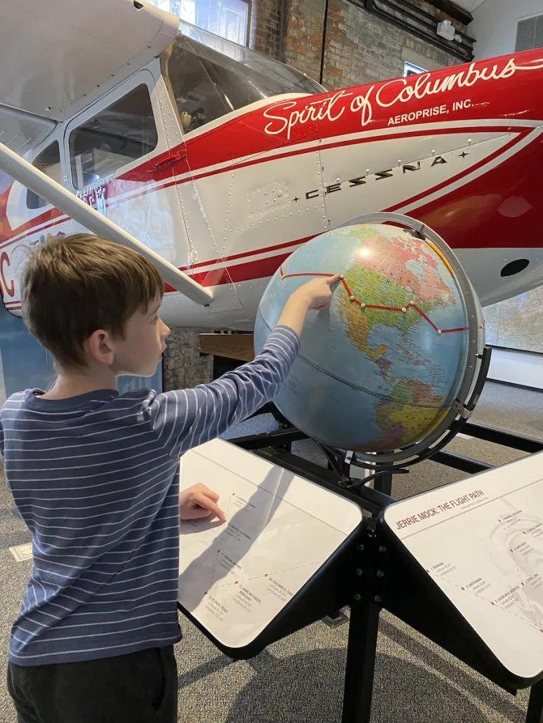 boy looking at a globe at the Jerrie Mock exhibit at The Works museum in Newark, Ohio.