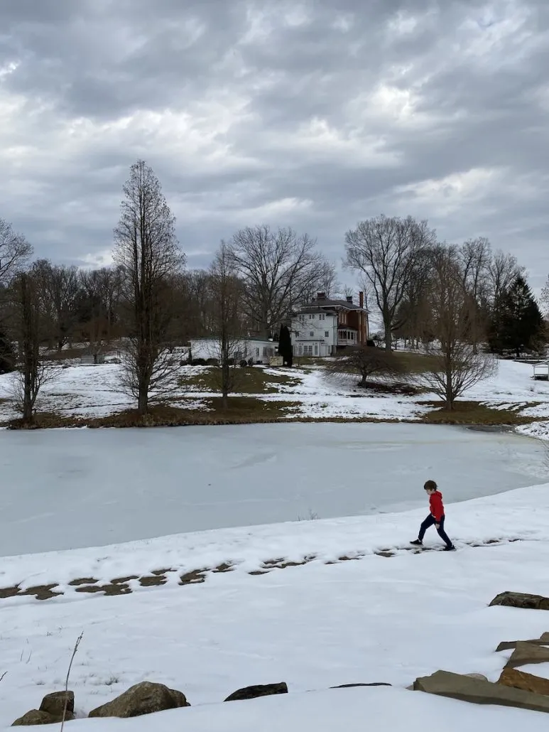 Boy walking a snowy path at the Dawes Arboretum in Newark, Ohio.