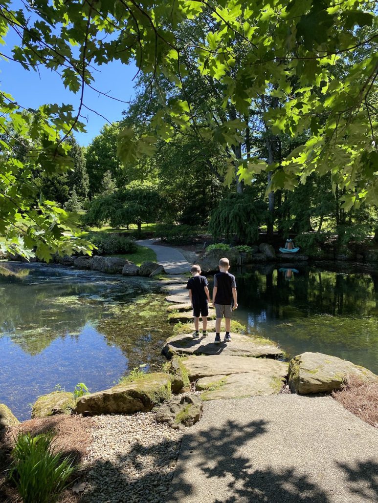 Boys walking across stones in the Japanese Garden at The Dawes Arboretum in Newark, Ohio.