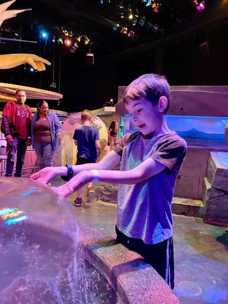 A boy playing in the water at the Oceans exhibit at the Center of Science and Industry in Columbus, Ohio.