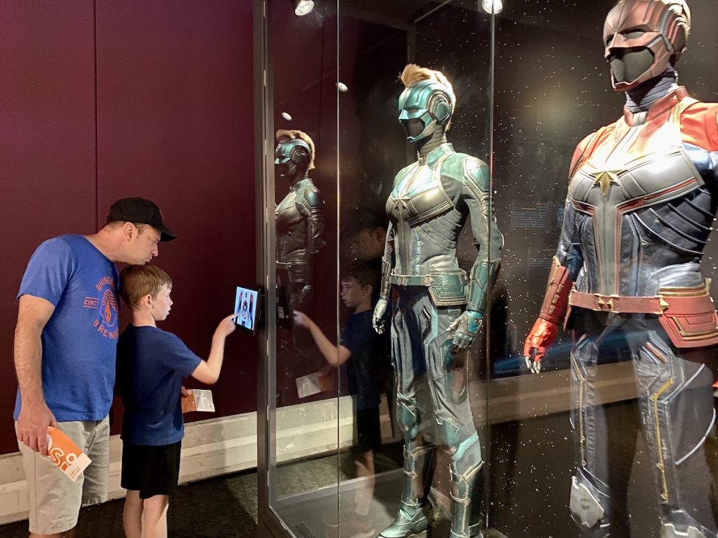 Boy and father looking at Marvel costumes at the limited engagement exhibit at COSI in Ohio.