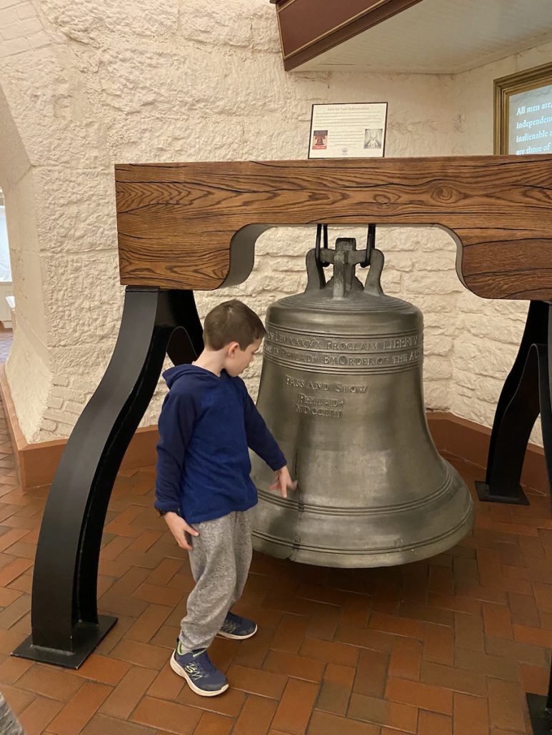 Boy touching the crack in the Liberty Bell replica at the Ohio Statehouse.