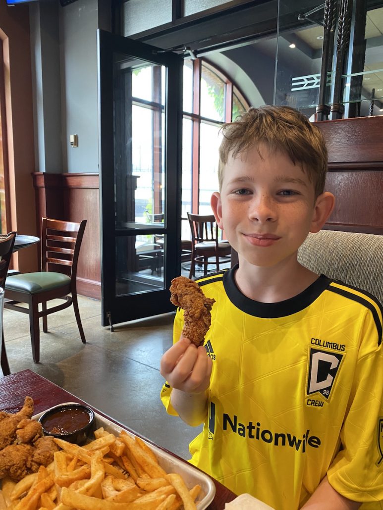A boy eating chicken at Goodwood Brewing in Columbus, Ohio Arena District.