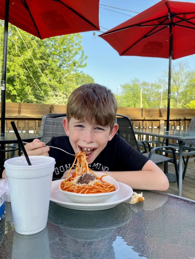 Boy eating spaghetti on the patio at The Oregon Inn, a family friendly restaurant near Toledo, Ohio.