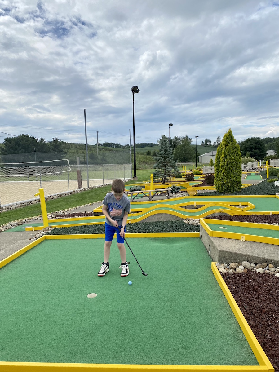 Boy playing mini golf, one of many fun things to do in Sugarcreek, Ohio.
