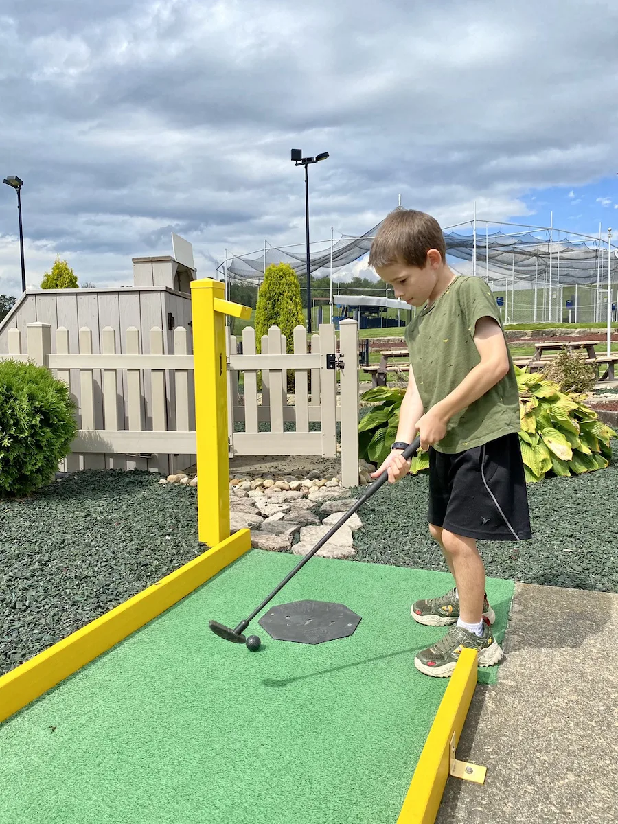 Boy playing mini golf at Cabin Creek Golf in Sugarcreek, Ohio.