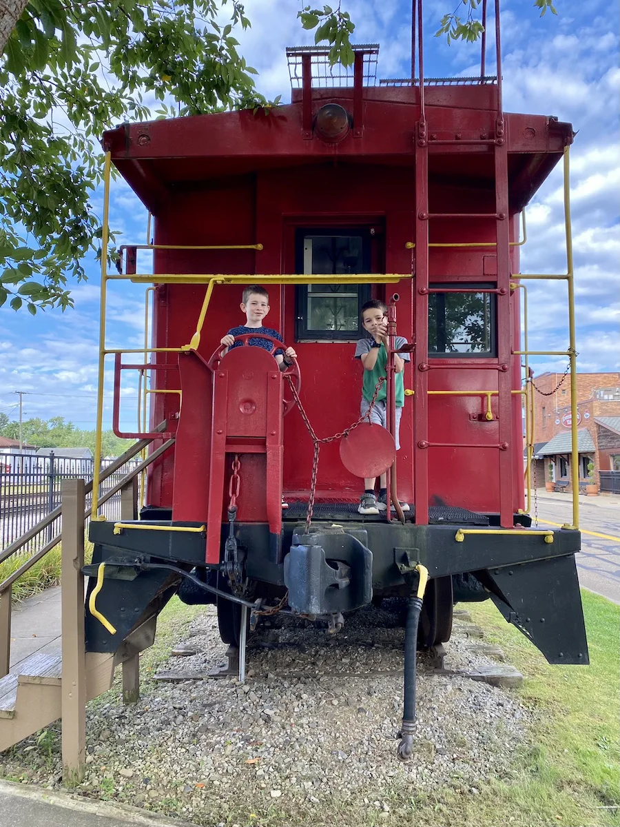 Two boys standing on a caboose at the Dennison Railroad Depot Museum in Tuscarawas County, Ohio.