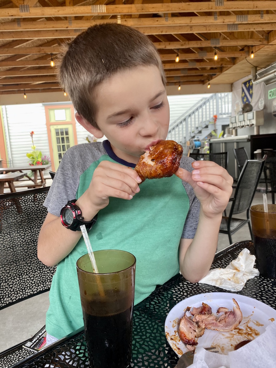 Boy eating chicken at Sublime BBQ.