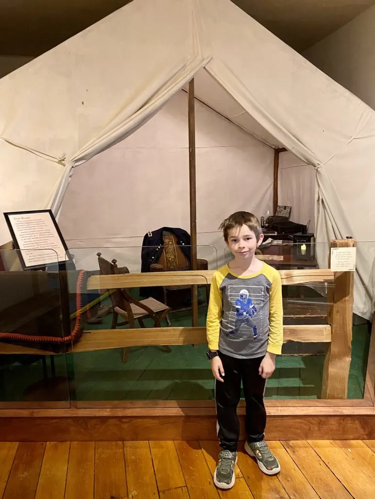 A boy standing in front of the civil war tent at the Sherman Museum in downtown Lancaster.