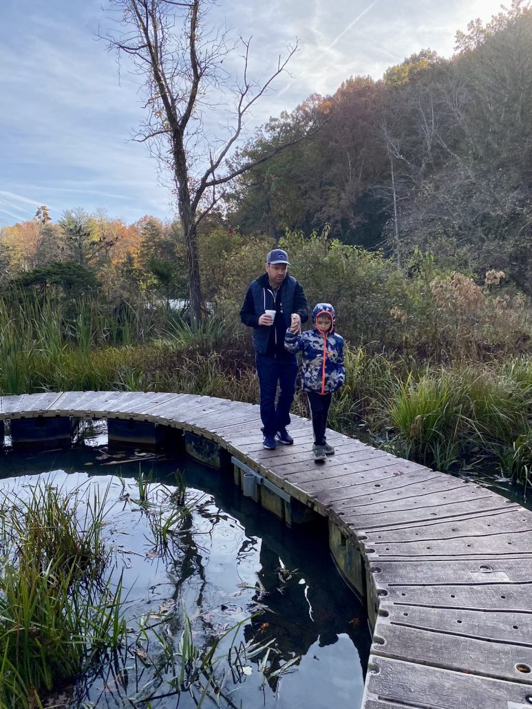 Dad and boy walking over the floating boardwalk trail at Wahkeena State Nature Preserve, a hidden gem in Ohio.