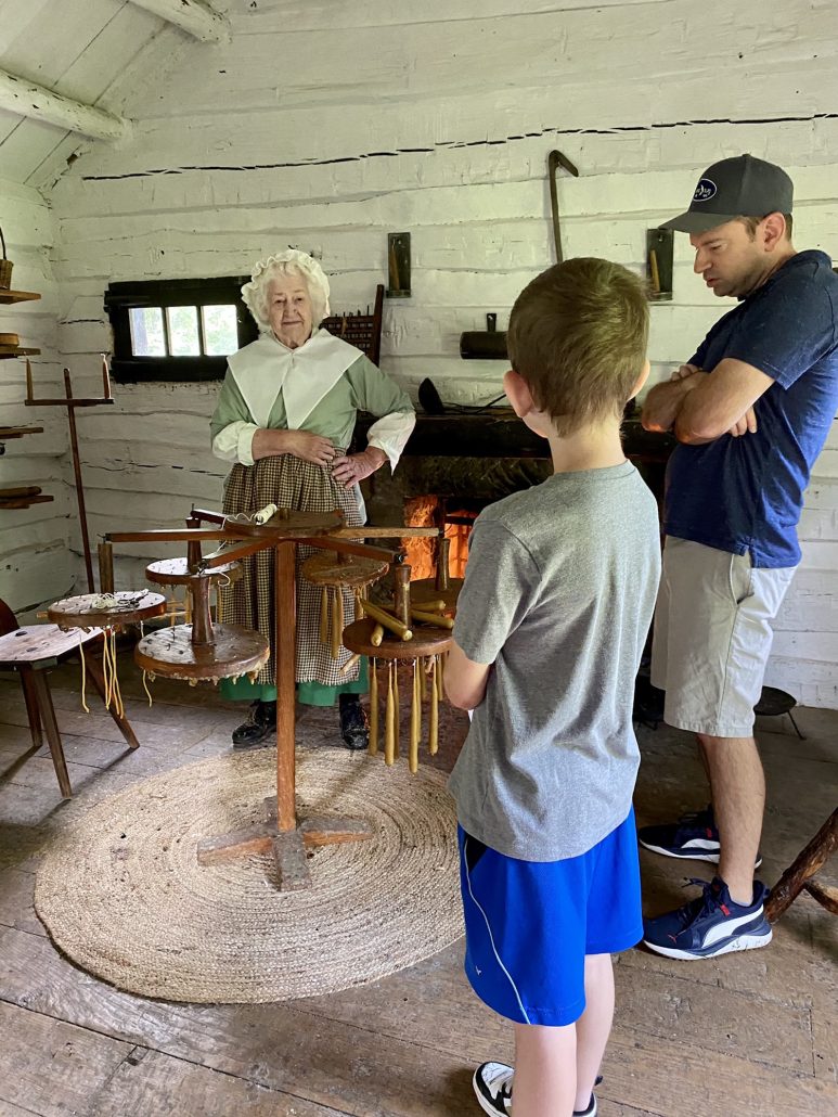A re-enactor teaching a family how they made candles in Schoenbrunn Village, a historical village in Ohio. 
