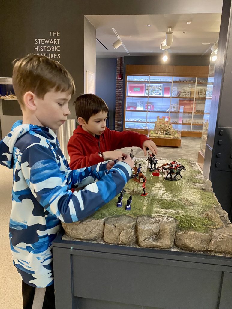 Two boys playing with toy soldiers at the Frazier History Museum, a kid-friendly attraction in Louisville, Kentucky.