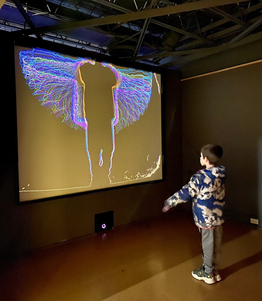 A boy watching his silhouette on the screen at Speed Art Museum, an attraction in Louisville, KY. 