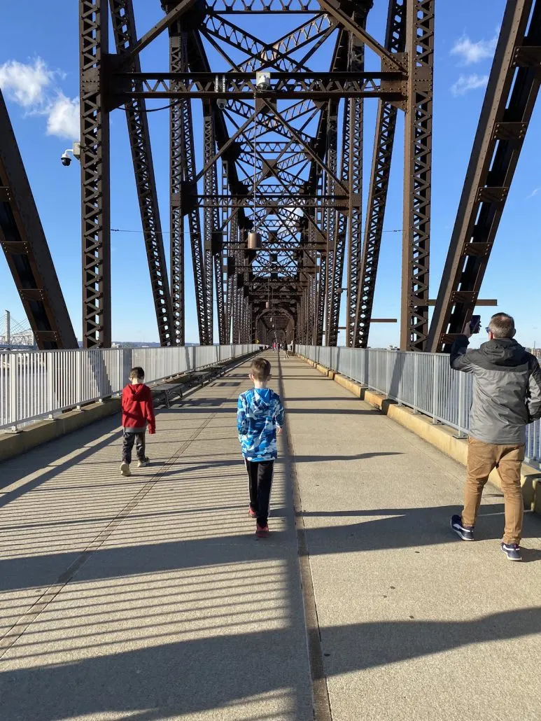 Two boys and father walking across the Big Four Bridge.
