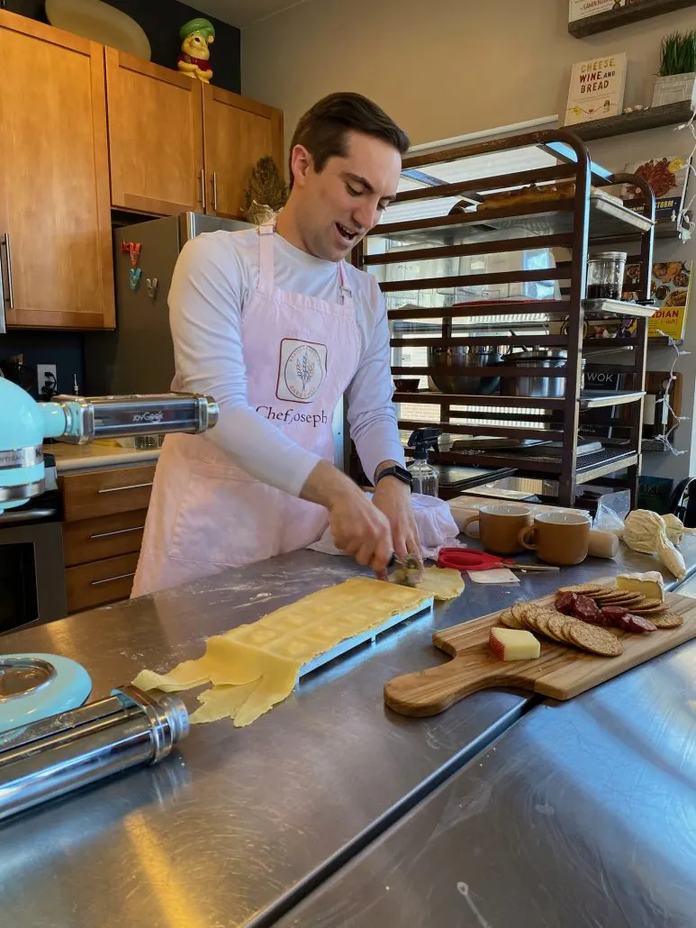 A man cutting ravioli at a cooking class date idea in Columbus, Ohio.