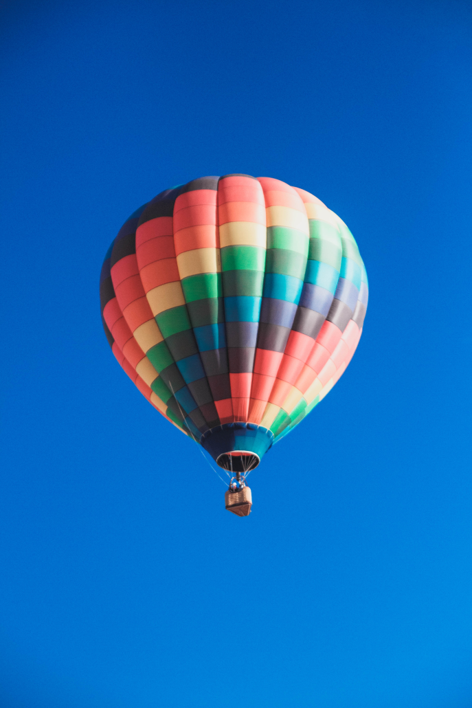 A colorful hot air balloon against a bright blue sky. Hot air balloon festivals in Ohio featured.