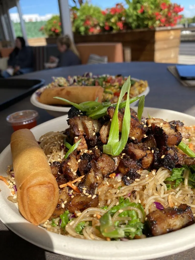 A meal of noodles and pork on top of the rooftop at Budd Dairy Food Hall, a date night spot in Columbus, Ohio.