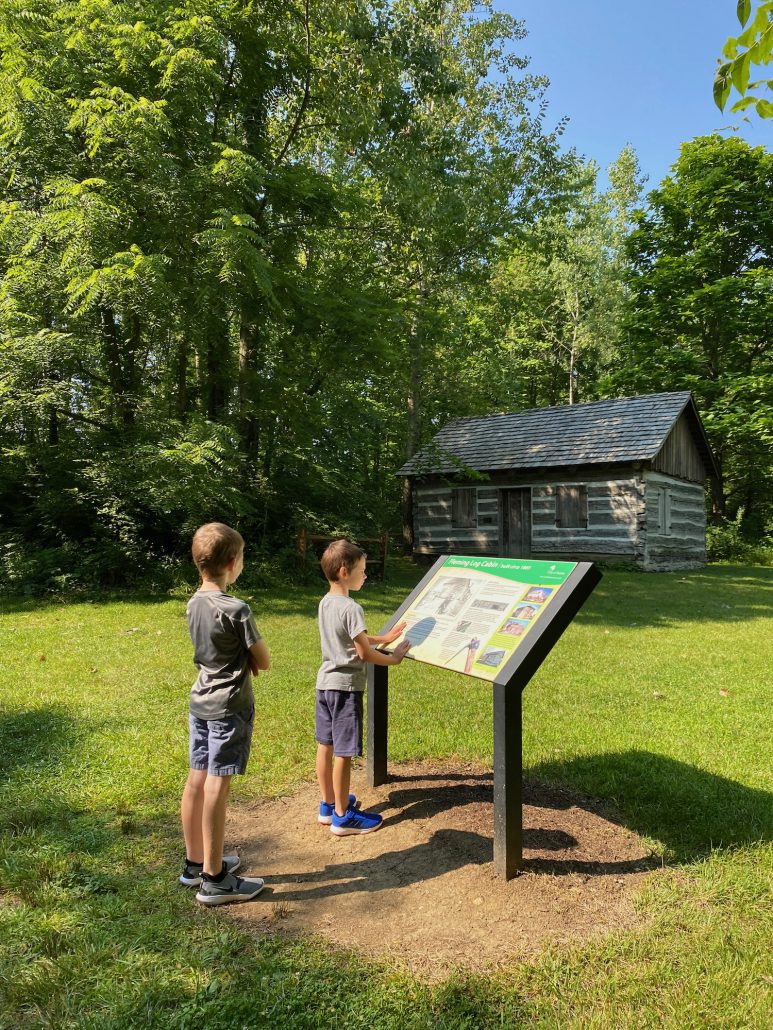 Two boys learning about the historic log cabin at ML Trabue Nature Reserve in Dublin, Ohio.